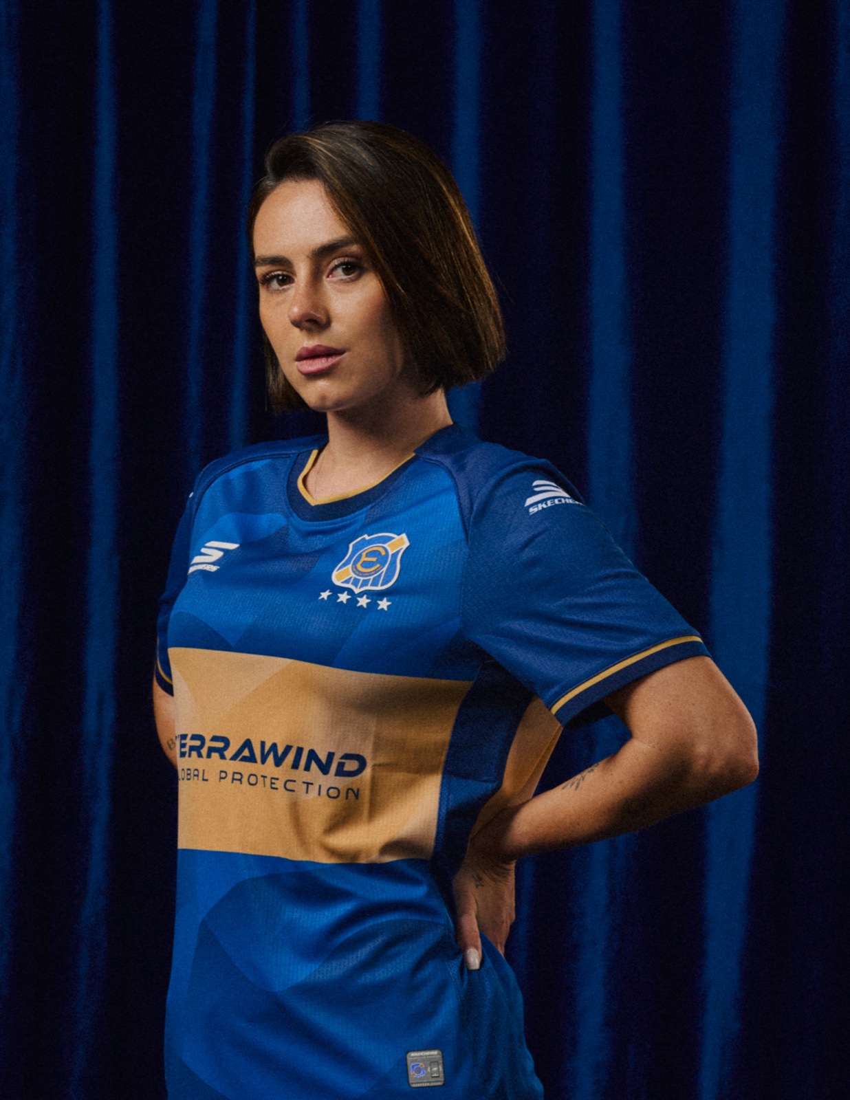 Retrato de jugadora con la camiseta oficial sobre terciopelo azul